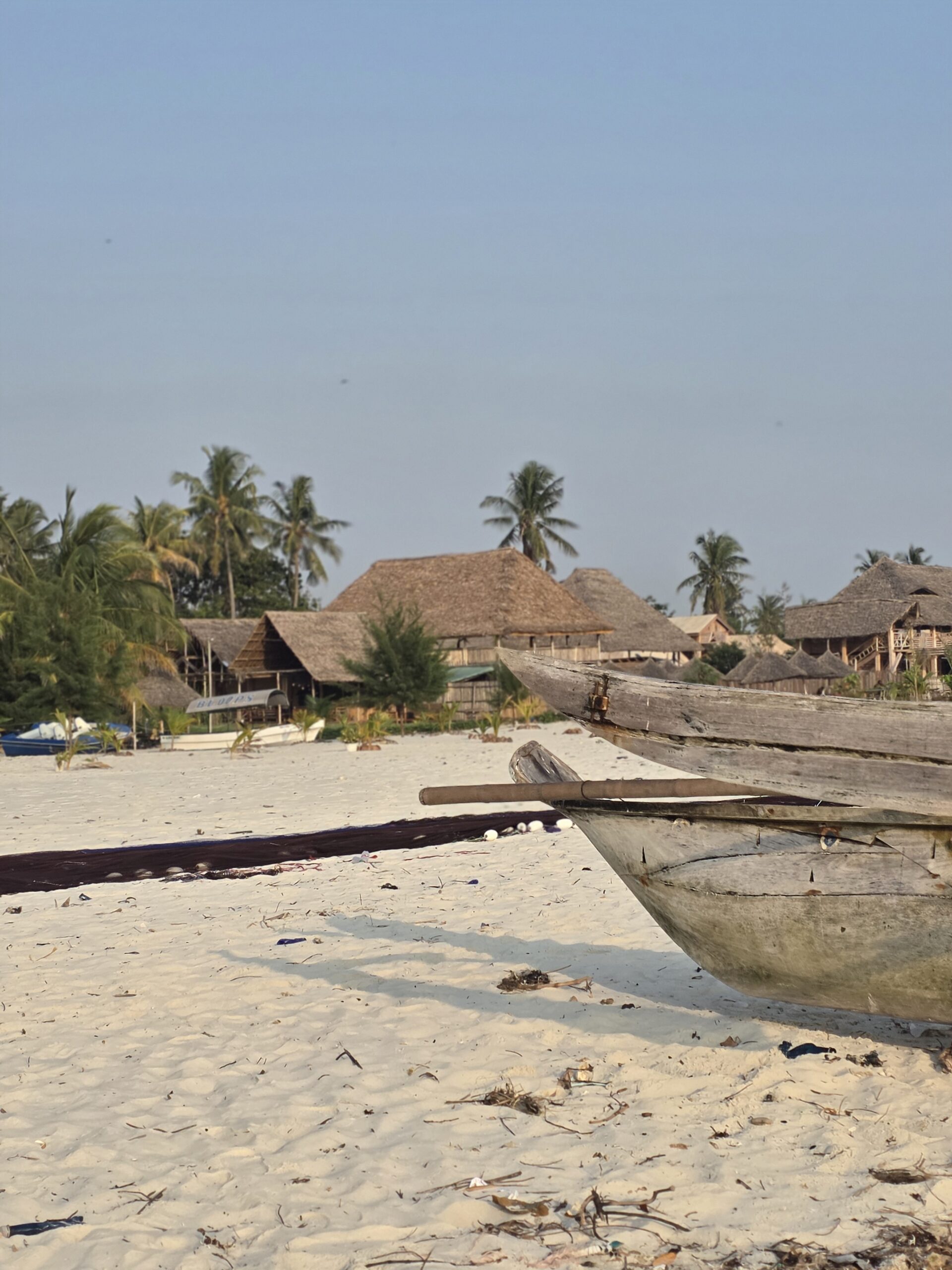 Beachfront lodge with thatched roofs and dhow boat, Msasani Peninsula, Dar es Salaam
